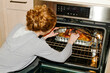 © Stas Pylypets/Stocksy - A girl is cooking poultry in the oven