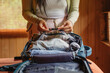 © Carlos Gonzales/Stocksy - Travel Woman Hands Packing Clothes in Backpack