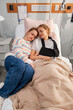 © Danil Nevsky/Stocksy - Teenage girl supporting injured friend resting in hospital bed
