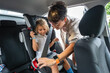 © Alvaro Lavin/Stocksy - Mother fastening seat belt for daughter in car before going to school