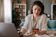 © Mihajlo Ckovric/Stocksy - Woman Shopping Online With Credit Card at Home Office Desk