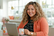 © Ivan Muñoz Colorado - Latin businesswoman working from home drinking tea and smiling
