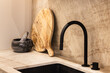 © VICTOR TORRES/Stocksy - Modern kitchen with black faucet and wooden accents