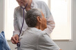 © Danil Nevsky/Stocksy - Doctor using stethoscope examining elderly patient in hospital room