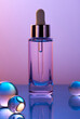 © Tatyana Lavrova/Stocksy - Dropper bottle with glass spheres on gradient purple background.