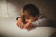 © Nasos Zovoilis/Stocksy - Young child resting peacefully on a cozy couch during the night