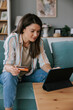 © Mihajlo Ckovric/Stocksy - Woman Using a Tablet for Online Shopping with a Credit Card
