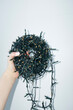 © Colour Laboratory/Stocksy - Hand holding Christmas festive fairy lights with hard flash