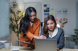 © amnaj - Asian businesswomen working together using laptop in office at night