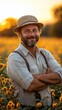 © kardaska - Farmer smiling with crossed arms in cultivated field at sunset
