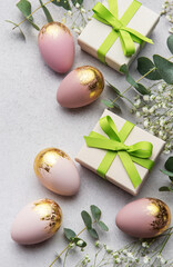 Wall Mural - Easter eggs and gift boxes decorated with eucalyptus leaves on concrete background