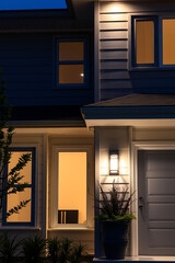 Sticker - Illuminated Modern House Exterior at Night. Captivating view of a contemporary home's exterior, beautifully lit at night. The architectural details and warm lighting create a welcoming ambiance.