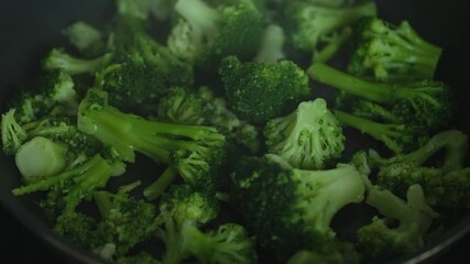 Wall Mural - Broccoli being cooked in a frying pan. Close up.