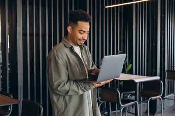 Young businessman working on laptop in modern office space
