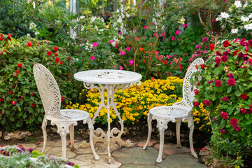 Wall Mural - Chairs and table in patio around with colorful flowerbed. Flower garden small patio with white chairs and table