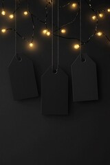 Poster - Three blank black gift tags hanging from string lights on dark background