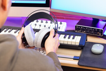 Wall Mural - studio headphone in male professional music producer hands. music production concept