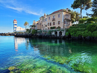 Wall Mural - santa maria lighthouse in cascais, portugal. beautiful calm azure water of the bay.
