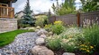 © Zeva - Backyard garden design, flowers, rocks, fence, home