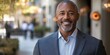 © Imagine Crane - A well-dressed man with a gray beard stands in a bustling urban area. Sunlight bathes the surroundings, highlighting the vibrant atmosphere and stylish architecture