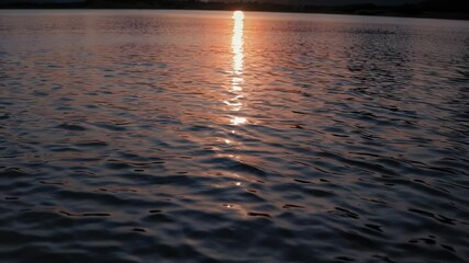 Aufkleber - a serene sunset over a mountain landscape with warm golden light reflecting on a calm lake.