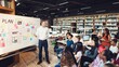 © Rawpixel.com - Diverse group of students in a library listens to teacher presenting at a whiteboard. Diverse students study in the library with teacher teaching in front of whiteboard. Students join class at library