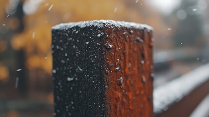 Wall Mural - Snowy winter day, wooden post, falling snow, blurred background, nature scene