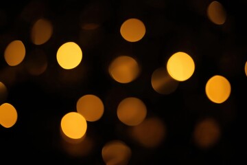 Poster - Golden bokeh lights creating a festive atmosphere on a dark background