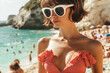 © ALL YOU NEED studio - closeup photo of a stylish woman standing on a crowded beach, wearing a retro-inspired red gingham bikini with a ruffled top, accessorized with bold white sunglasses