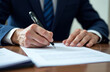 © Julia - Close-up of hands signing a document, sleeves of a business suit are visible, business papers on the table.