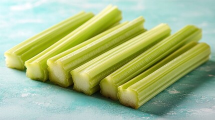 Wall Mural - Closeup of Fresh Green Celery Stalks on Aqua Background