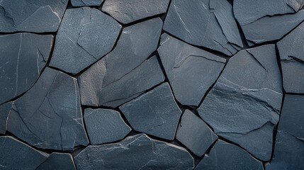 Poster - A close-up view of a textured slate stone wall, showcasing irregularly shaped stones in various shades of gray