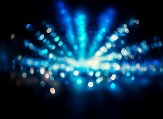 Aufkleber - Blurred blue and white bokeh lights radiate from a central point on a dark background, creating an abstract and luminous effect. The lights are soft and out of focus, suggesting movement or distance.