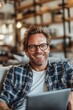 © Ilja - Smiling Young Man with Glasses Relaxed on Couch, Browsing Laptop, Enjoying Leisure Time at Home,