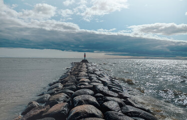 Wall Mural - A lighthouse stands on a rock in front of the sea