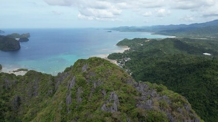 Wall Mural - A breathtaking aerial view of El Nido, Palawan, Philippines, featuring lush green mountains, turquoise waters, limestone cliffs, and a coastal town.