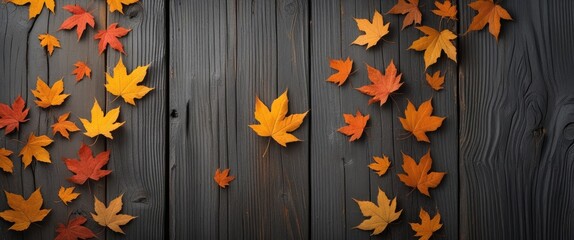 Wall Mural - Autumn leaves scattered on a dark wood background creating a rustic and warm atmosphere perfect for nature-inspired designs.