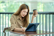 © Yingyaipumi - Beautiful asian woman happy to drink coffee and working outside office.Thinking about how to take the business to technological heights.attractive young businesswoman working at outdoor