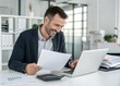 © Aminograpix - Happy Businessman Reviewing Documents on Laptop