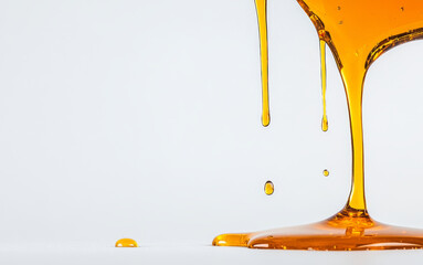 Poster - Golden honey trickles down from a container, creating elegant splashes and droplets.