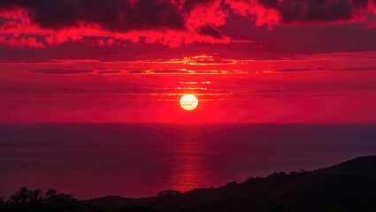 Wall Mural - Vibrant sunset over calm ocean with dramatic red and orange sky reflecting on the water creating a serene and picturesque landscape.