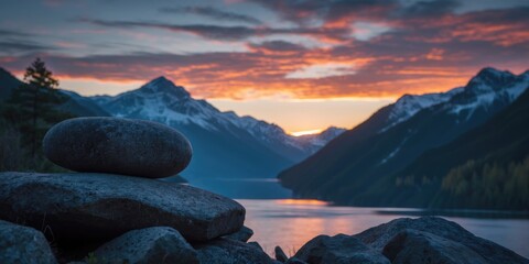 Wall Mural - serene sunset over mountain lake with silhouetted rocks and soft focus ideal for nature background a