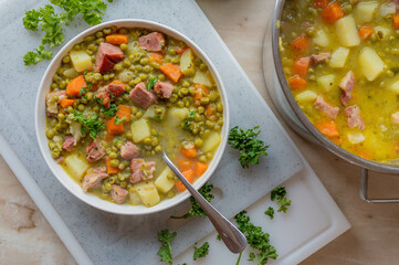 Wall Mural - Homemade hearty pea soup with pork meat and vegetables on a plate.