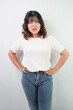 © Rizky - Beautiful young asian woman with wavy hair wearing white shirt is showing angry face expression and hand on waist gesture with sad face expression, isolated over white background.