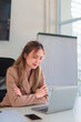 © snowing12 - Young Asian businesswoman working on a laptop at her office desk in a clean and organized workspace