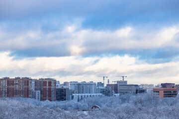 Wall Mural - snow clouds over city park in winter evening