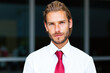 © Minerva Studio - Portrait of a confident businessman posing outdoors with a red tie