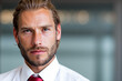 © Minerva Studio - Serious businessman with beard and red tie posing in office