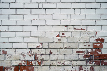 Old brick wall with peeling white paint on red bricks, showing weathered texture. Copy space. Background