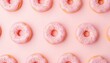 © Monster - Donuts rosados ​​esmerilados con chispas dispuestas sobre un fondo rosa claro. Los donuts tienen una base de color marrón dorado y están espaciados uniformemente